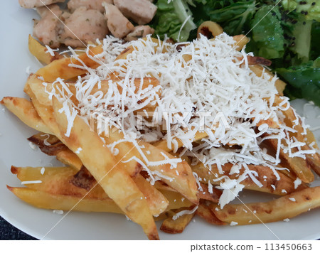 Homemade grilled chicken with french fries, cheese and green salad, served on a white plate 113450663