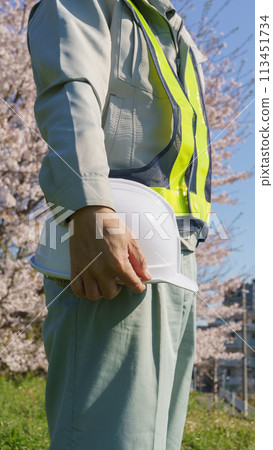 一個穿著櫻花和頭盔的工作服的男人 一個穿著櫻花和頭盔的工作服的男人 113451734