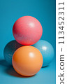 Three colorful eggs stacked on top of each other against a blue background, AI 113452311