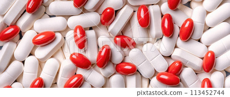 Medicine background from bunch white and red pills in capsule macro. 113452744