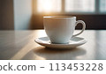 A hot cup of coffee on a saucer, set against a white background, casting a subtle shadow. 113453228