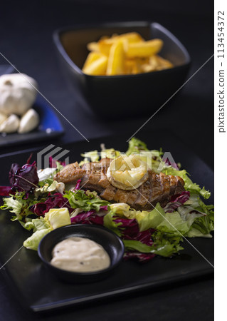 Duck breast with salad and baked goat cheese 113454372
