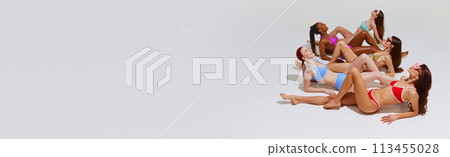 Banner. Diverse women in colorful bikinis lounging in synchronized as on sandy beach against white studio background. 113455028