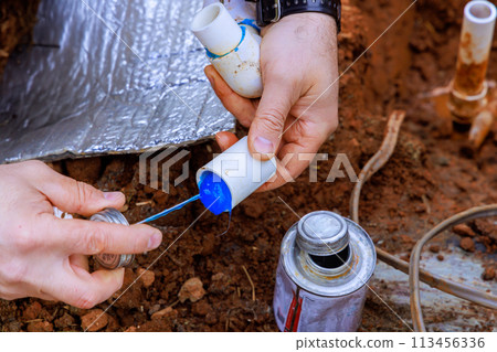 Before gluing plastic pipe with glue, plumber seals that pipe with glue 113456336