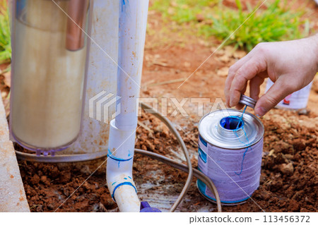 Glue is applied to pipe before it is glued by plumber 113456372