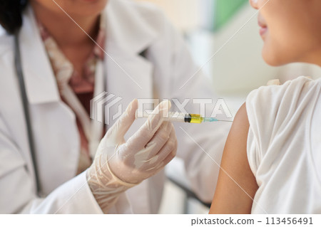 Closeup image of medical worker injecting vaccine in arm of patient 113456491