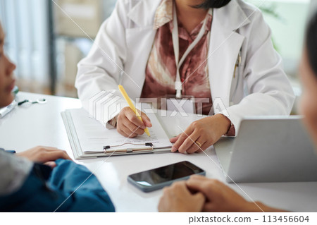 Pediatrician talking to patient and filling medical history Pediatrician talking to patient and filling medical history 113456604