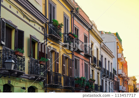 Cagliari historic center colorful buildings facade with wooden window shutters and iron balconies in Sardinia Island, Italy. 113457717