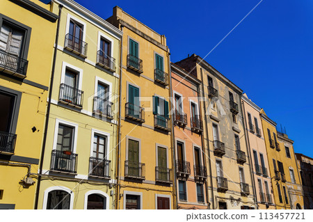 Cagliari historic downtown colorful buildings with wooden window shutters and iron balconies under clear blue sky in Sardinia Island, Italy. Cagliari historic downtown colorful buildings with wooden window shutters and iron balconies under clear blue sky in Sardinia Island, Italy. 113457721