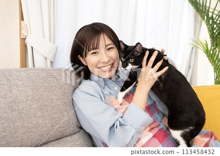Smiling woman holding a cat 113458432
