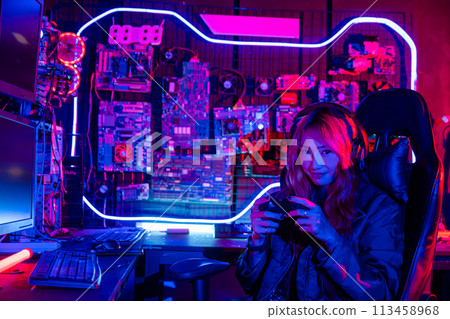 Gamer using joystick controller for virtual tournament plays online video game with computer neon lights, woman wear gaming headphones playing live stream esports games console at home Gamer using joystick controller for virtual tournament plays online video game with computer neon lights, woman wear gaming headphones playing live stream esports games console at home 113458968