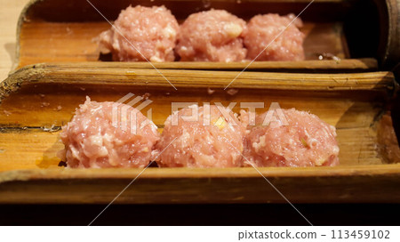 Tsukune is a type of Japanese meatball most often made from seasoned chicken mince. Served in a bamboo skewer and cook them yakitori style over a charcoal grill in Yakitori Japanese restaurant. 113459102