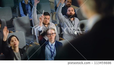 Diverse journalists raise hands and ask questions during press campaign 113459886