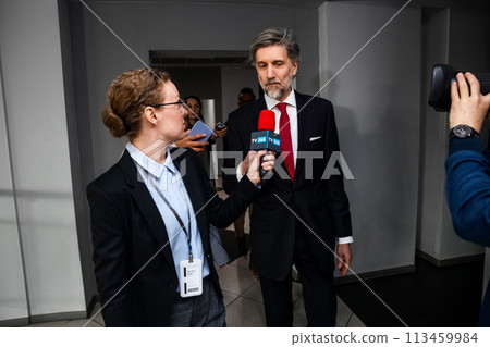 Mature organization representative answers press questions 113459984