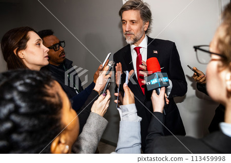 Busy republican politician gives interview for TV news in corridor 113459998