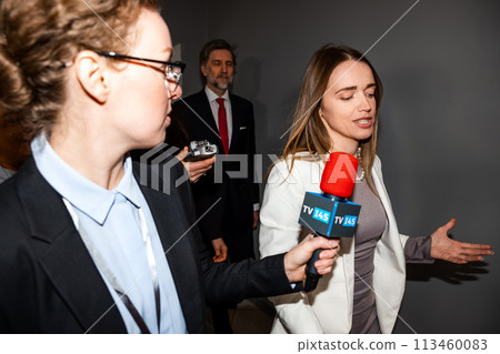 Confident female politician answers press questions walking in hallway Confident female politician answers press questions walking in hallway 113460083