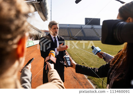 Interview of private investor for TV news in soccer stadium 113460091