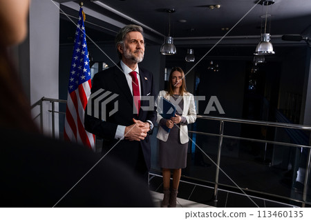 President of the USA waves his hand and poses for media cameras 113460135