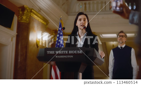 Female president of United States surrounded by journalists 113460514