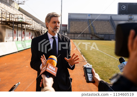 Interview of private investor for TV news in soccer stadium Interview of private investor for TV news in soccer stadium 113460519