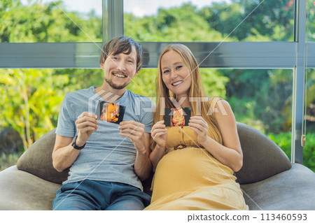 In a touching moment, the pregnant woman and father connect via video call, sharing the joy as they hold up an ultrasound photo, bridging the distance with the anticipation of their baby's arrival 113460593