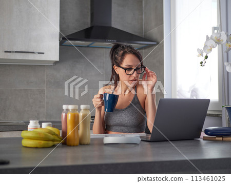 brunette woman in the kitchen at home is preparing fruit 113461025