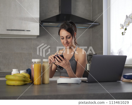 brunette woman in the kitchen at home is preparing fruit 113461029