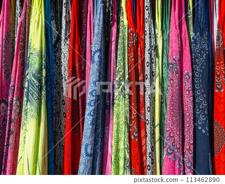 Multicolored colorful scarves hang on the counter under sunlight. Multicolored colorful scarves hang on the counter under sunlight. 113462890