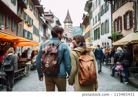 A couple strolling down a cobblestone street in the city 113465431