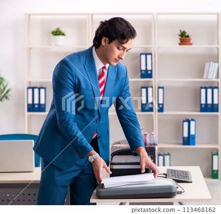 Young employee making copies at copying machine 113468162