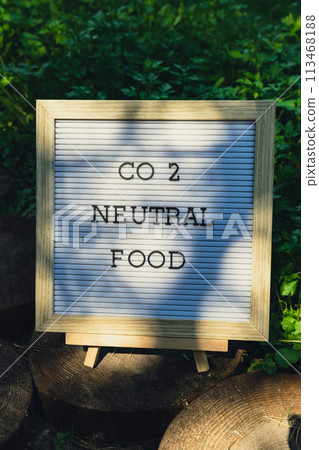 CO2 NEUTRAL FOOD message on background of fresh eco-friendly bio grown green herb parsley in garden. Countryside food production concept. Locally produce harvesting. Sustainability 113468188