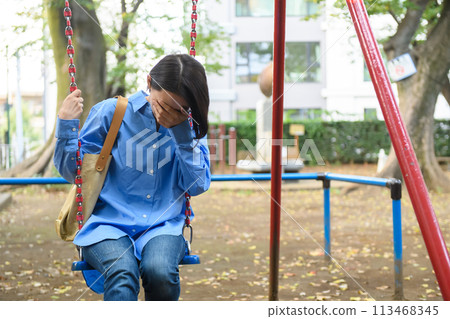 A woman killing time in the park 113468345