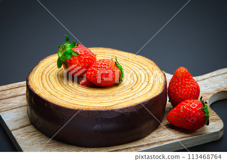 Delicious chocolate covered Baumkuchen served with fresh strawberries Delicious chocolate covered Baumkuchen served with fresh strawberries 113468764