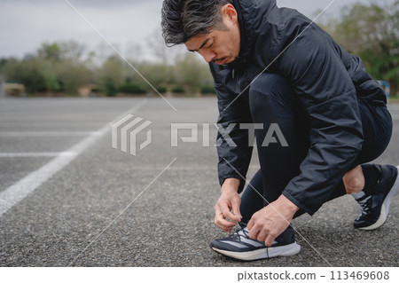 男人慢跑前繫鞋帶 男人慢跑前繫鞋帶 113469608