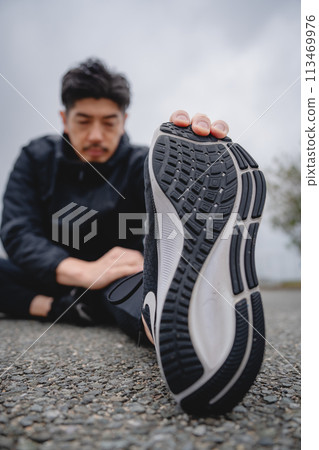 Man doing flexibility exercises outdoors Man doing flexibility exercises outdoors 113469976