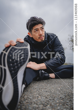 Man doing flexibility exercises outdoors Man doing flexibility exercises outdoors 113469988