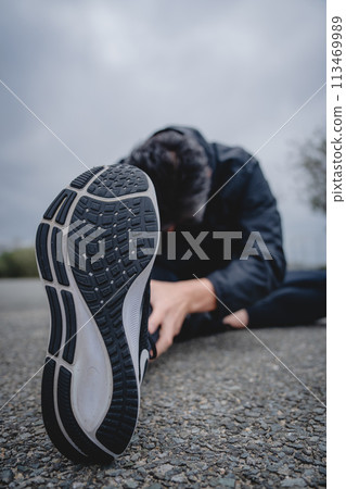 Man doing flexibility exercises outdoors Man doing flexibility exercises outdoors 113469989