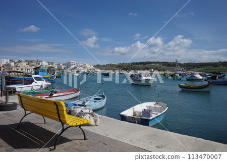 馬耳他馬爾薩什洛克港口景觀，有黃色長凳和許多漂浮的船隻 113470007