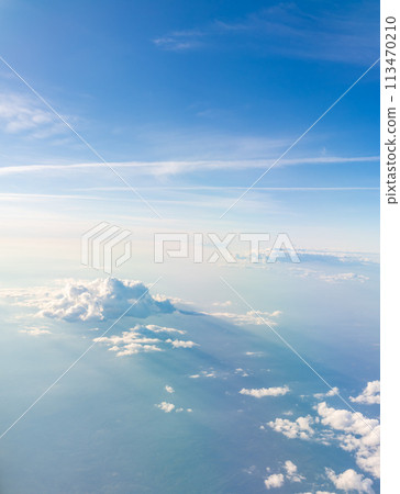 Aerial view from airplane window above green ground. View from the airplane window with beautiful clouds at sunrise 113470210