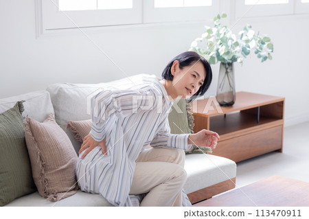 Lower back pain - middle-aged woman with lower back pain Lower back pain - middle-aged woman with lower back pain 113470911