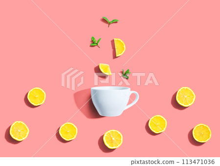 Fresh yellow lemons with tea cup overhead view 113471036