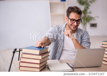 Young male student preparing for exams in the classroom 113471147