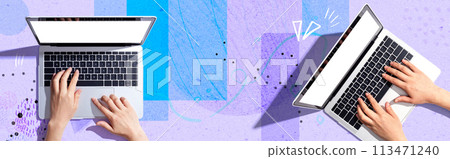 Two people working together with laptop computers Two people working together with laptop computers 113471240