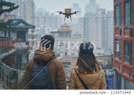 Two people are standing on a sidewalk, looking up at a drone flying overhead. logistic concept Two people are standing on a sidewalk, looking up at a drone flying overhead. logistic concept 113471448