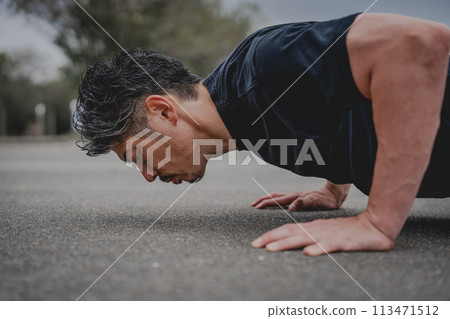 A man in his 40s doing strength training outdoors A man in his 40s doing strength training outdoors 113471512
