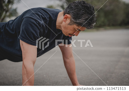 一名40多歲的男子在戶外進行肌肉訓練 113471513