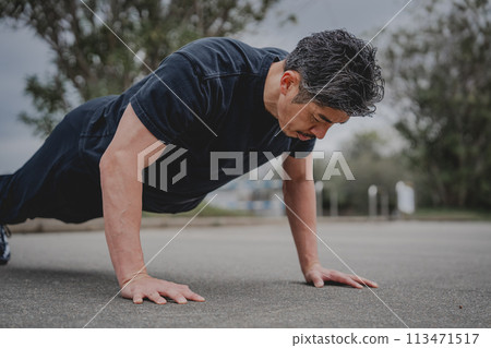 一名40多歲的男子在戶外進行肌肉訓練 一名40多歲的男子在戶外進行肌肉訓練 113471517