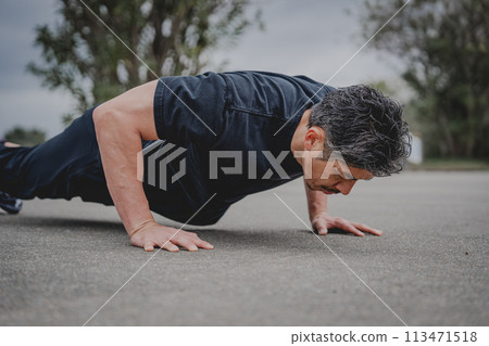 一名40多歲的男子在戶外進行肌肉訓練 一名40多歲的男子在戶外進行肌肉訓練 113471518