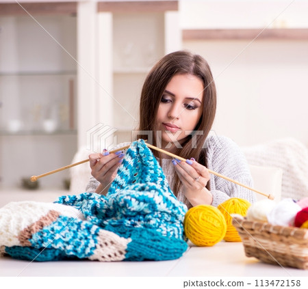 Young beautiful woman knitting at home Young beautiful woman knitting at home 113472158