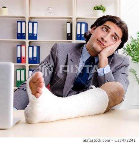 Leg injured employee working in the office Leg injured employee working in the office 113472241